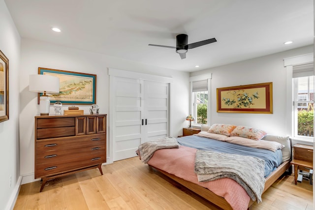 bedroom with light wood finished floors, recessed lighting, multiple windows, and a ceiling fan