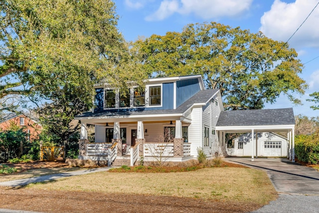 view of front of property featuring aphalt driveway, an attached carport, covered porch, and a front lawn