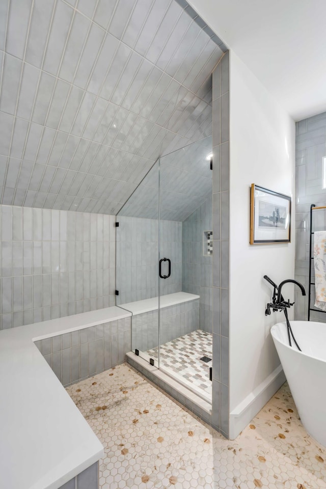 full bath featuring baseboards, a freestanding bath, a shower stall, and tile patterned flooring