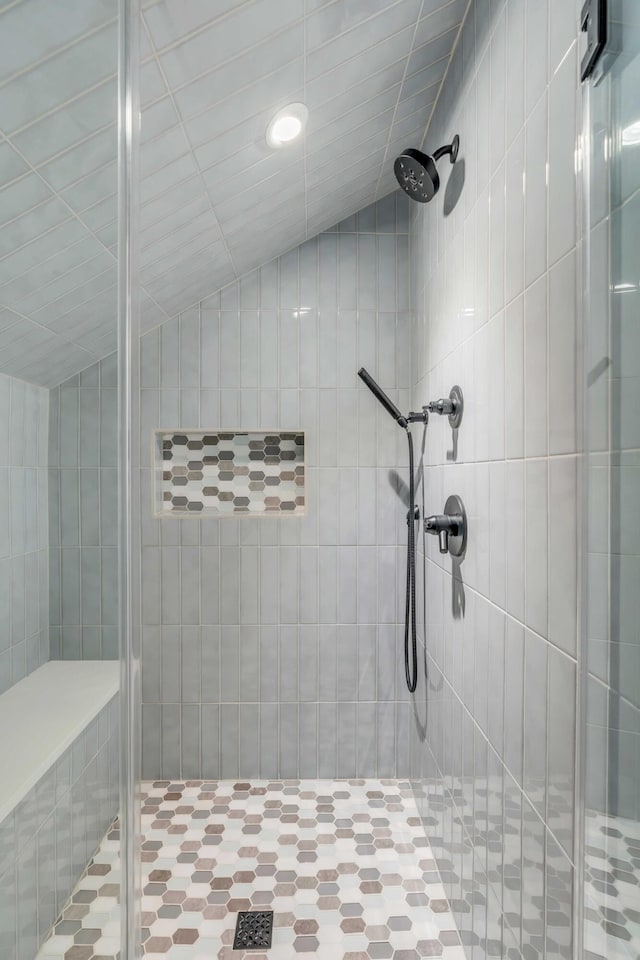 bathroom featuring lofted ceiling and a stall shower