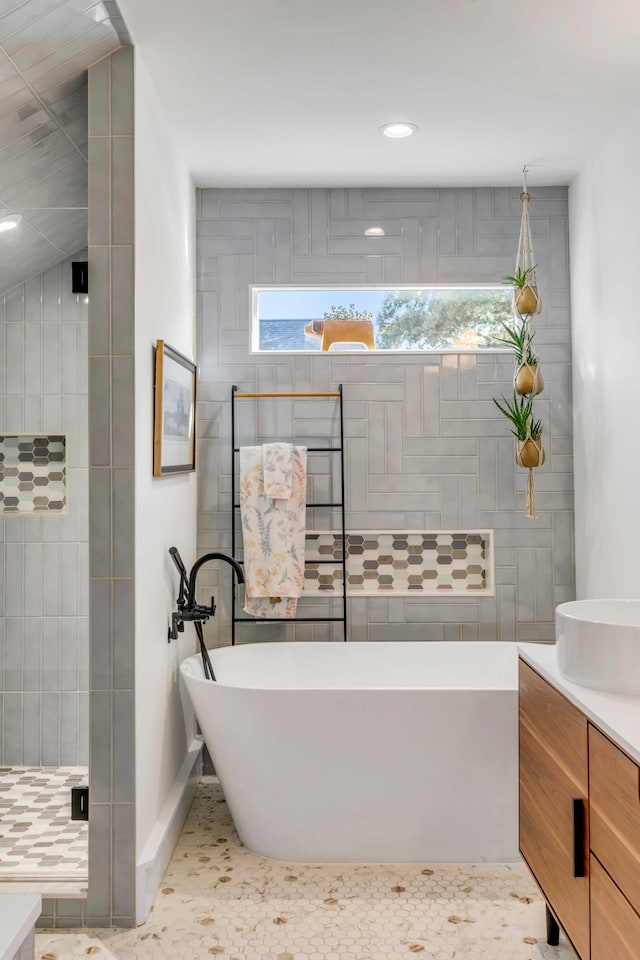 full bathroom featuring vanity, recessed lighting, tiled shower, and a freestanding bath