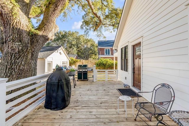 wooden deck featuring a grill and fence