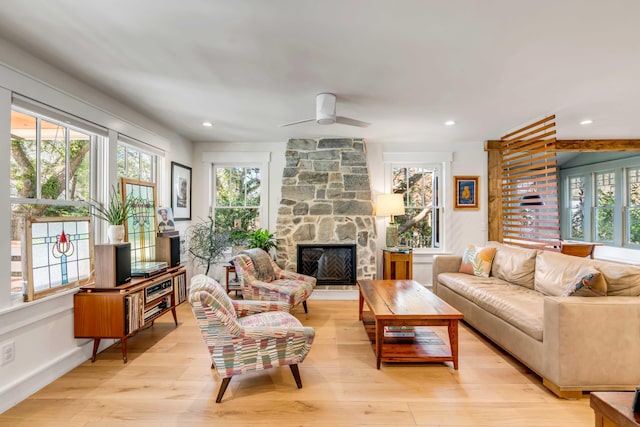 living room with a healthy amount of sunlight, a fireplace, and light wood-type flooring