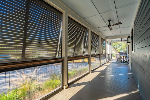 unfurnished sunroom with a ceiling fan