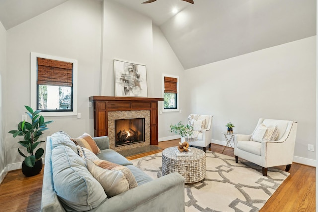 living room featuring a wealth of natural light, a fireplace, high vaulted ceiling, and wood finished floors