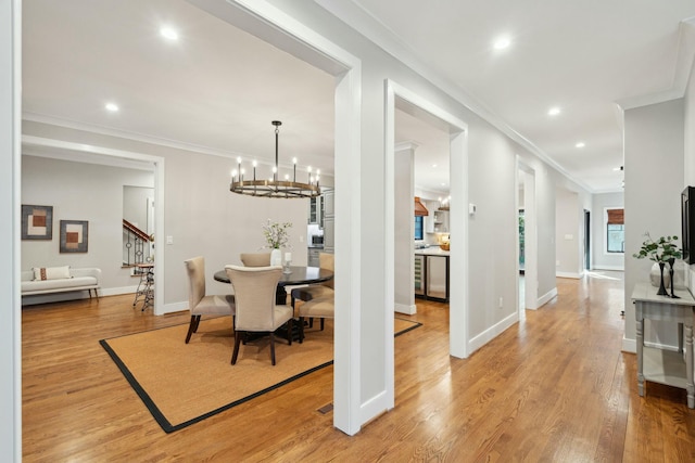 dining room with recessed lighting, a notable chandelier, baseboards, light wood-style floors, and crown molding