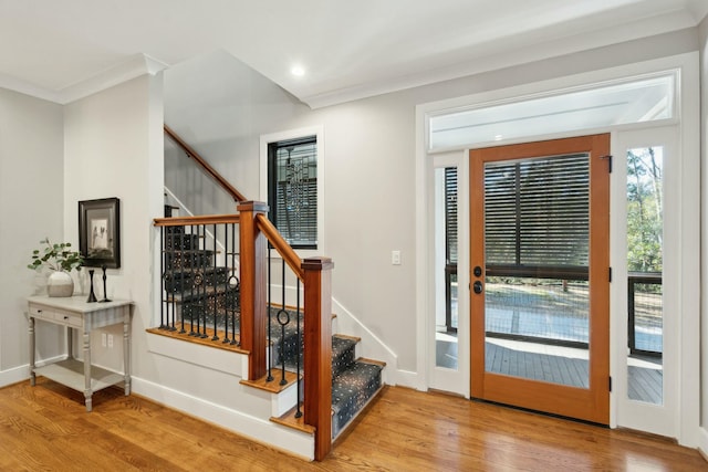 doorway to outside featuring ornamental molding, stairway, wood finished floors, and baseboards