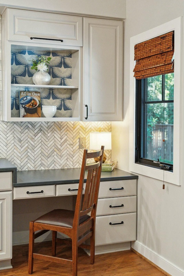 office with built in desk, wood finished floors, and baseboards