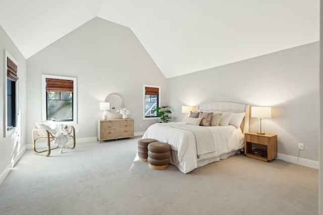 carpeted bedroom with high vaulted ceiling and baseboards