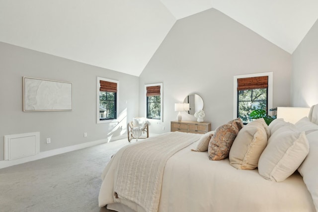 carpeted bedroom featuring high vaulted ceiling and baseboards