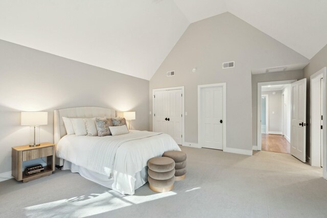 bedroom with baseboards, high vaulted ceiling, visible vents, and light colored carpet