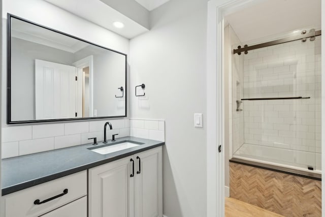 bathroom with a tile shower, vanity, and decorative backsplash