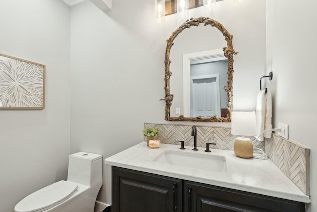 bathroom with toilet, vanity, and decorative backsplash