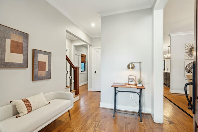 hall with stairs, baseboards, crown molding, and wood finished floors