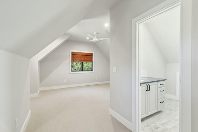 bonus room with baseboards, vaulted ceiling, and light colored carpet