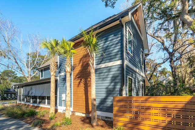 view of side of home featuring crawl space and a sunroom