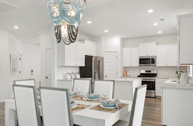 dining area featuring sink, hardwood / wood-style floors, and a notable chandelier