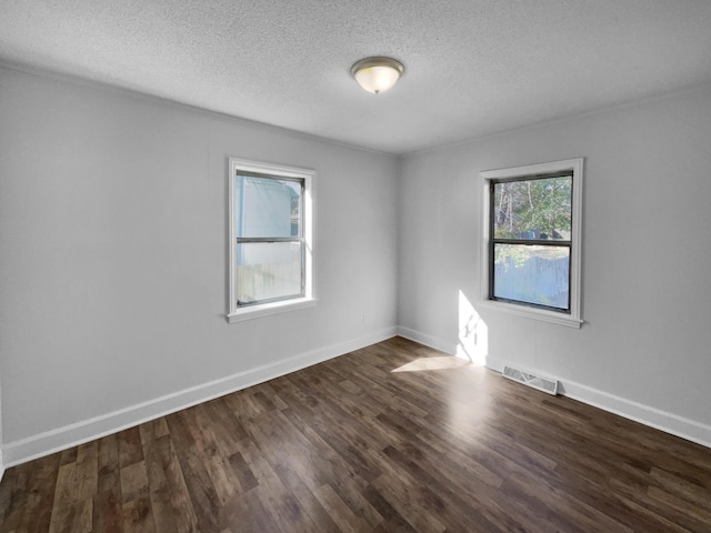 unfurnished room with a textured ceiling and dark hardwood / wood-style flooring