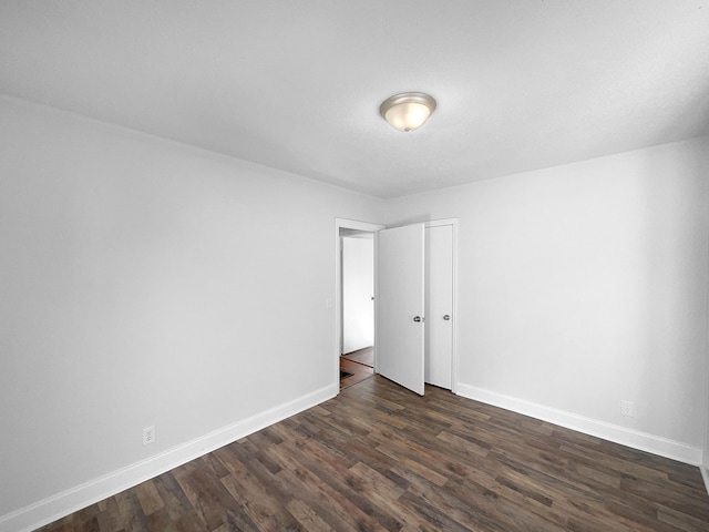 empty room with dark hardwood / wood-style floors