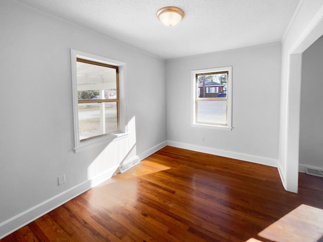 spare room with dark wood-type flooring and a textured ceiling