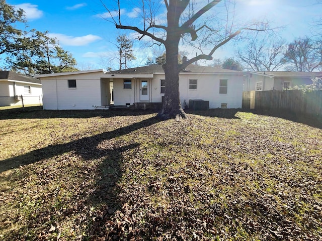 rear view of house featuring central AC and a yard