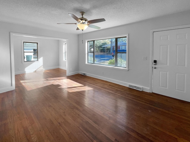 interior space featuring ceiling fan, dark hardwood / wood-style floors, and a textured ceiling