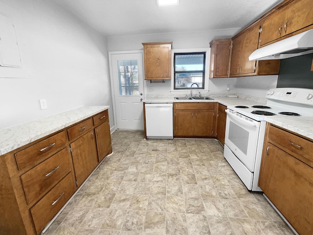 kitchen with light stone counters, sink, and white appliances