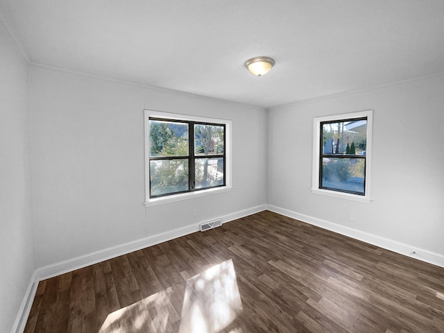 unfurnished room with dark hardwood / wood-style flooring and crown molding