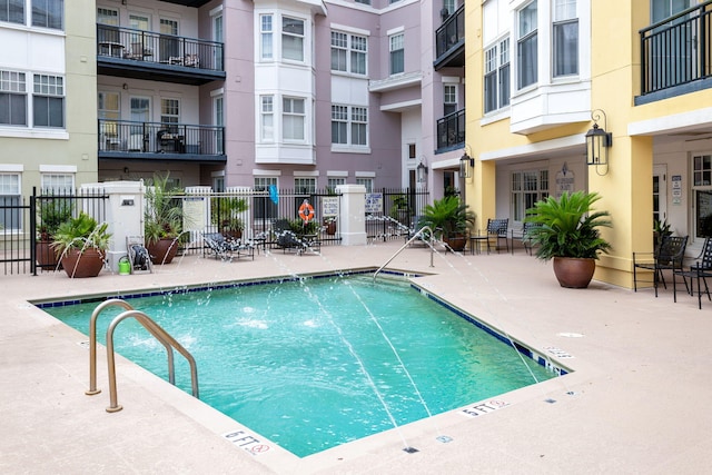 pool with a patio and fence