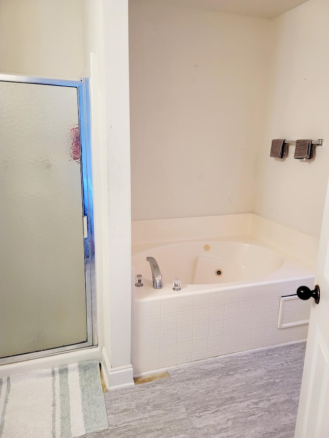 full bath with a jetted tub, a shower stall, and wood finished floors