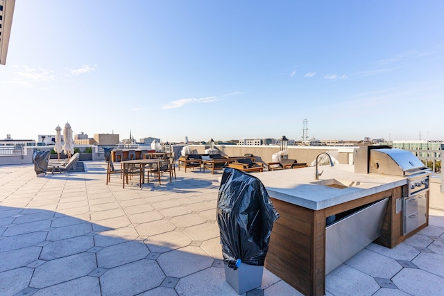 view of patio / terrace with a bar, a grill, and an outdoor kitchen