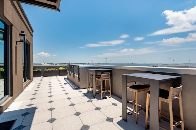 view of patio / terrace featuring a water view and exterior bar