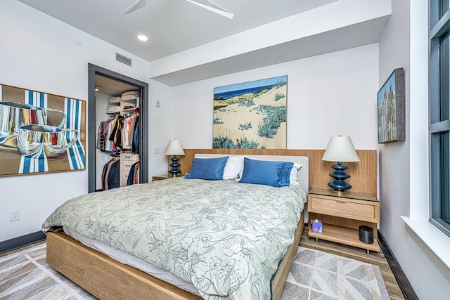 bedroom featuring ceiling fan, a closet, and a walk in closet