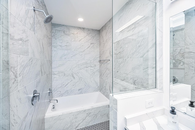 bathroom featuring tile walls and tiled shower / bath combo