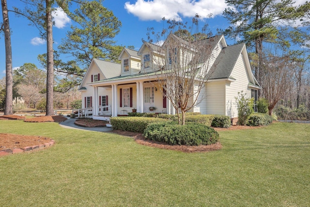 view of front of property with a shingled roof, a front yard, and covered porch