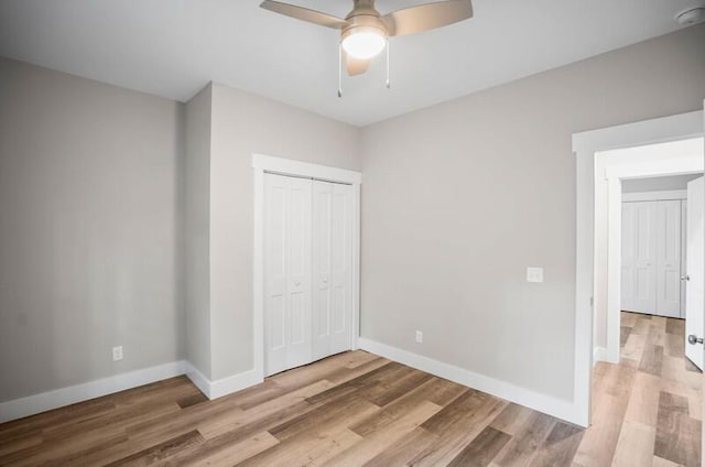 unfurnished bedroom featuring a ceiling fan, light wood-type flooring, a closet, and baseboards