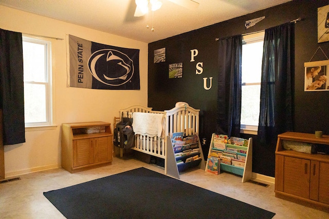 bedroom featuring a nursery area and ceiling fan