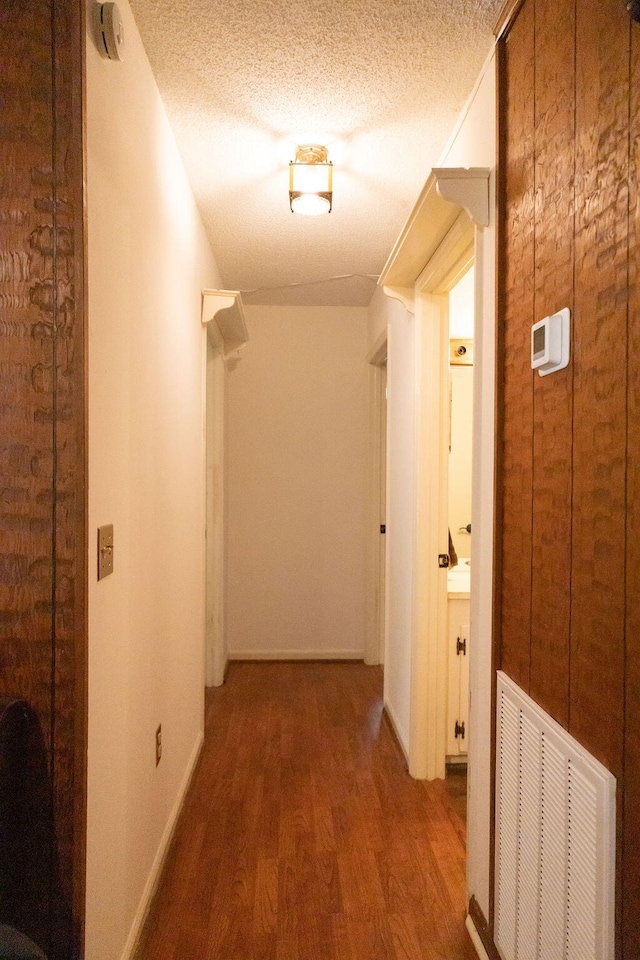 hall featuring hardwood / wood-style floors and a textured ceiling