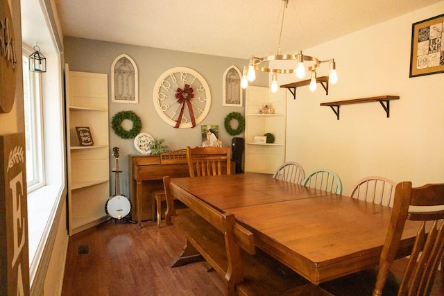 dining space featuring dark hardwood / wood-style floors and a chandelier