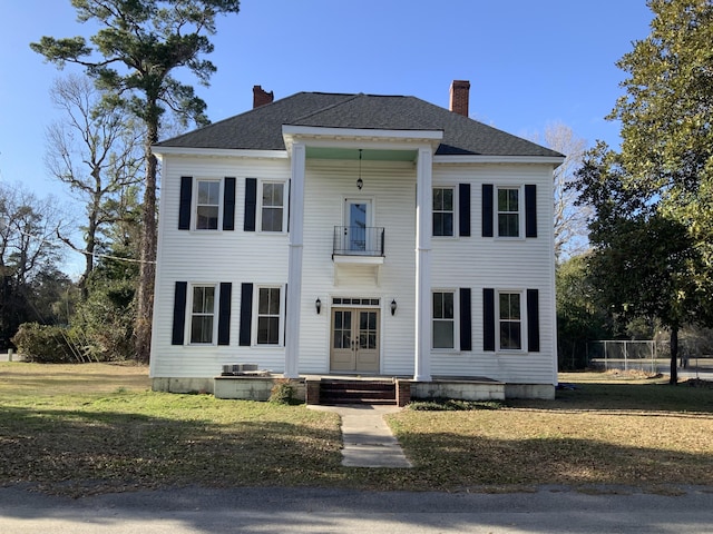 view of front of house featuring french doors and a front lawn