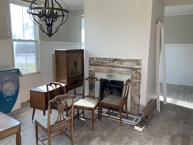 sitting room with an inviting chandelier, wood-type flooring, and a fireplace