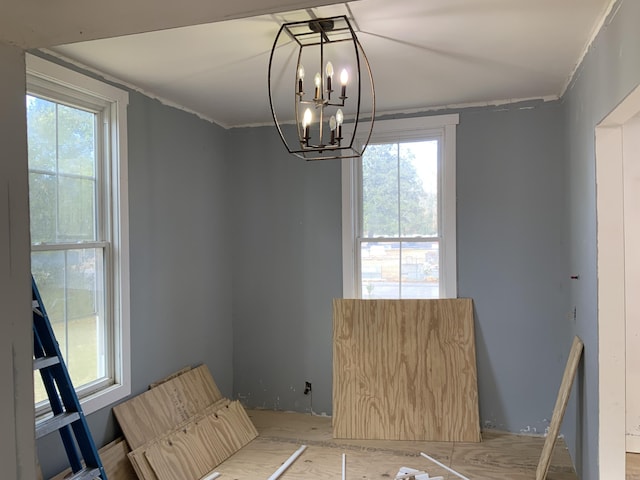 unfurnished room featuring an inviting chandelier