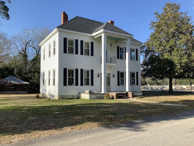 greek revival house featuring a front yard