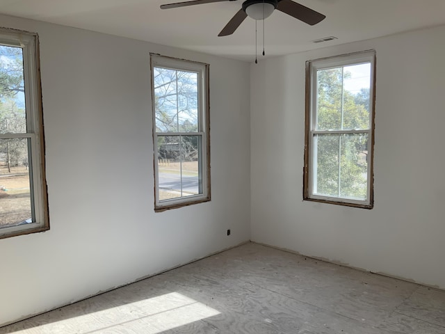 spare room featuring ceiling fan and a healthy amount of sunlight