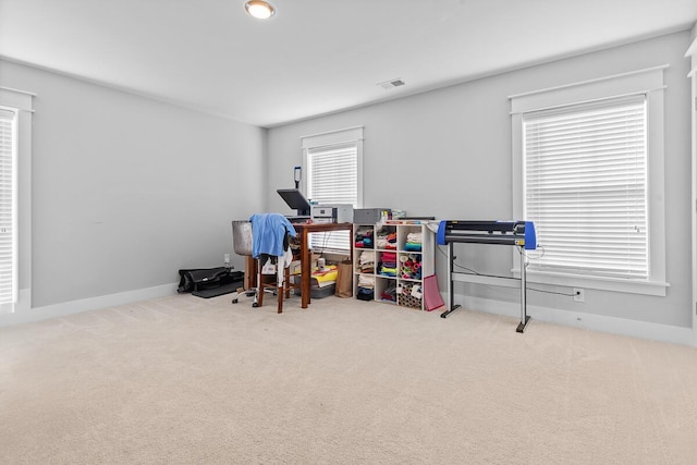 office area featuring baseboards, visible vents, and light colored carpet