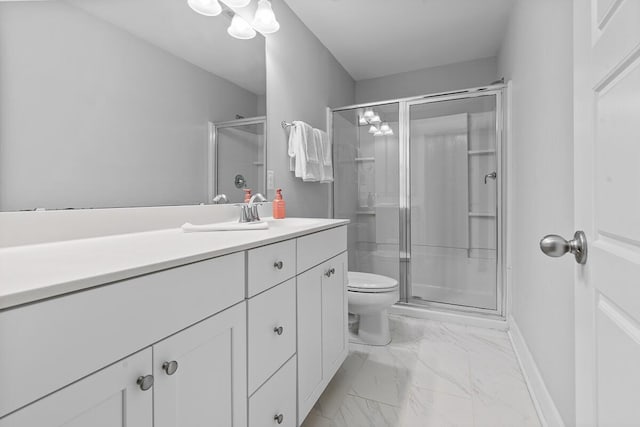 bathroom with toilet, vanity, baseboards, marble finish floor, and a shower stall