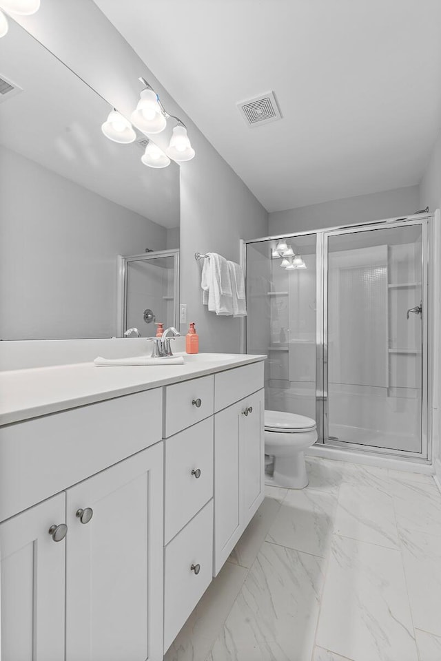 full bath with toilet, vanity, visible vents, marble finish floor, and a stall shower