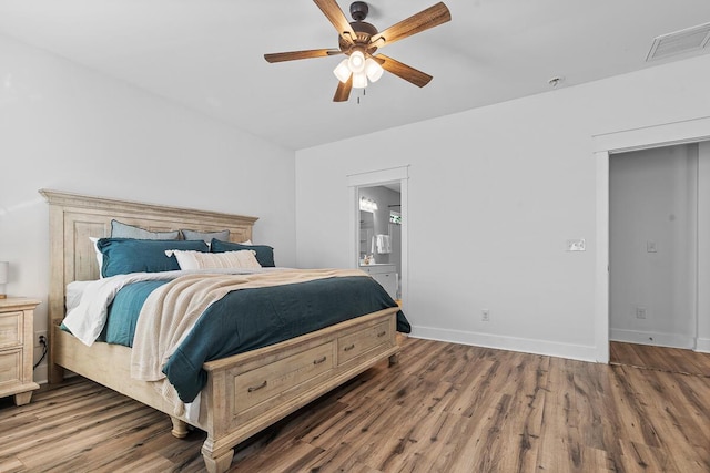 bedroom featuring dark wood-style flooring, ensuite bath, visible vents, and baseboards