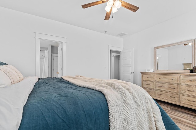 bedroom featuring light wood-style floors, connected bathroom, visible vents, and ceiling fan