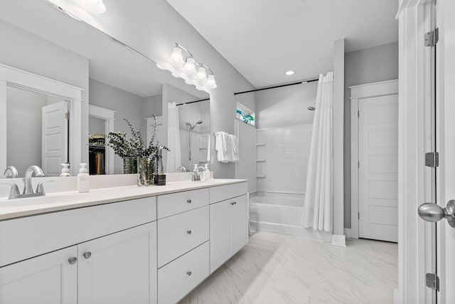 full bathroom with double vanity, marble finish floor, shower / bath combo, and a sink